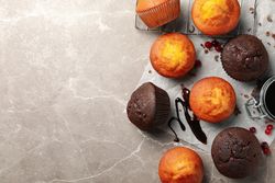 Composition with delicious muffins, berries, chocolate and baking paper