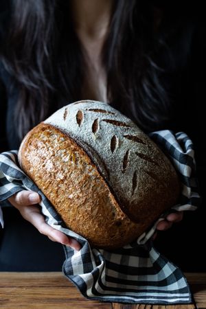Crop person holding some bread