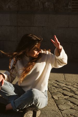 Cheerful female sitting on pavement