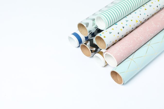 Rolls of festive wrapping paper on light background. Space for text