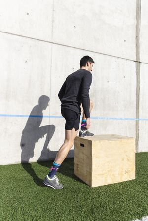 Man training on sports ground near wall