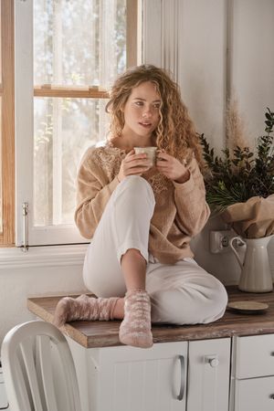 Young woman drinking hot coffee at home
