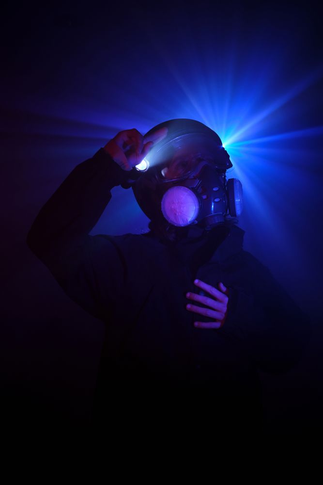 Robber in mask standing in dark studio
