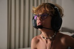 Crop young man in headphones and glasses sitting on a chair