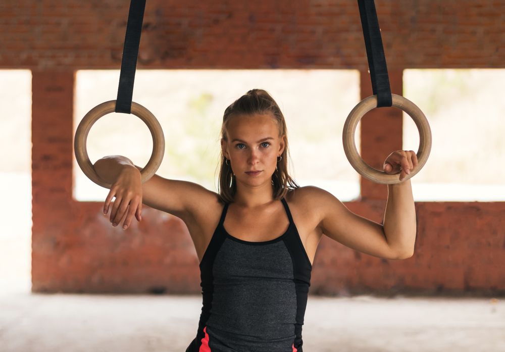 portrait of a female athlete with gymnastic rings.