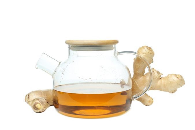 teapot with tea and ginger, isolated on plain background