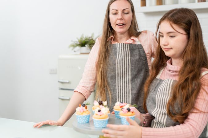 Mom teaching little girl baking
