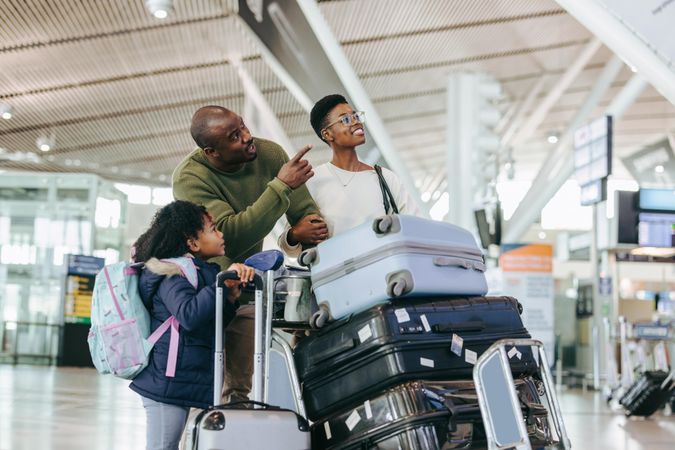 Black family of three waiting for aircraft at airport terminal