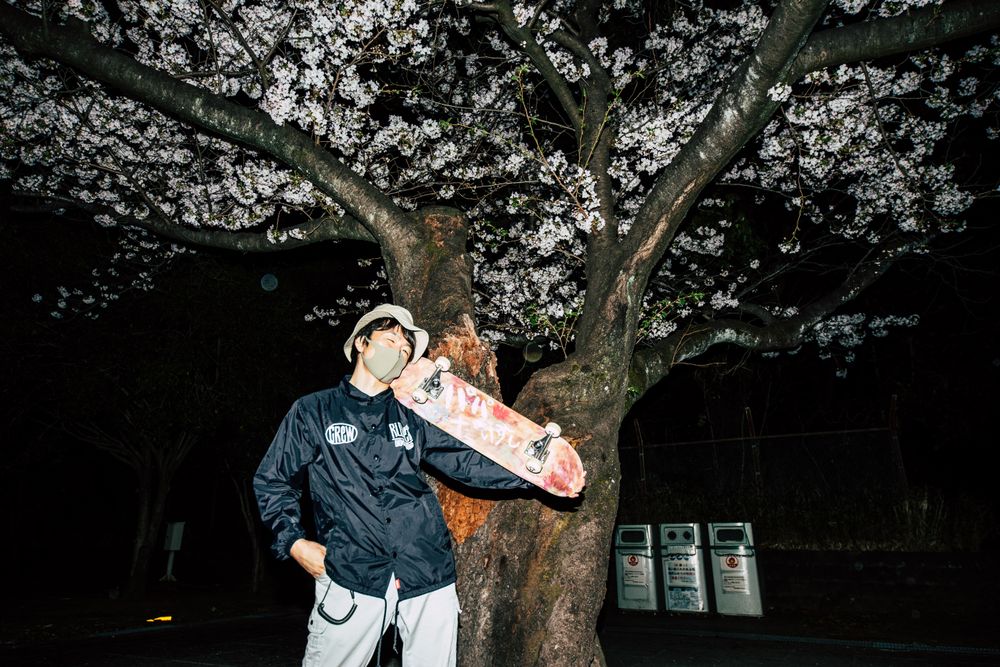 Man wearing facemask and helmet holding a skateboard