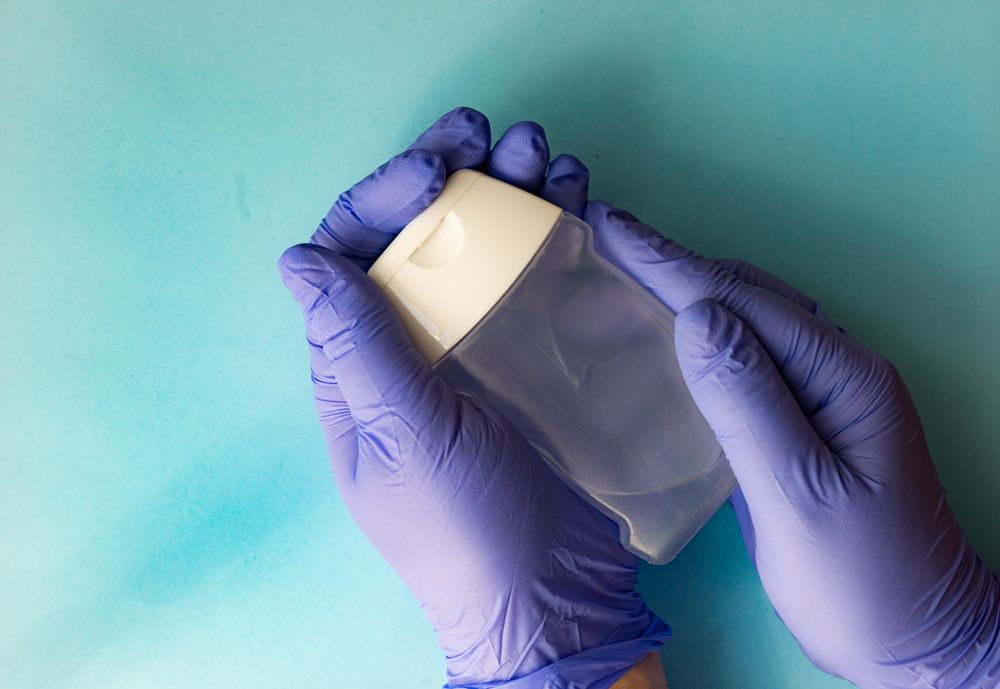 Covid-19 virus concept looking down at hands in purple latex gloves holding soap