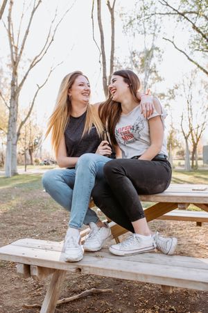 Friends hugging and laughing in park
