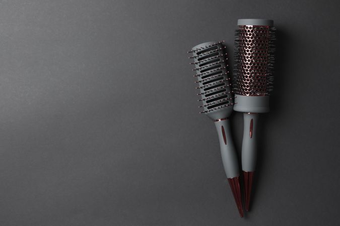 Hair brushes on dark background, space for text
