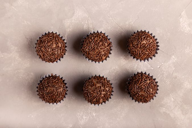 Top view of chocolate truffles with sprinkles on marble surface