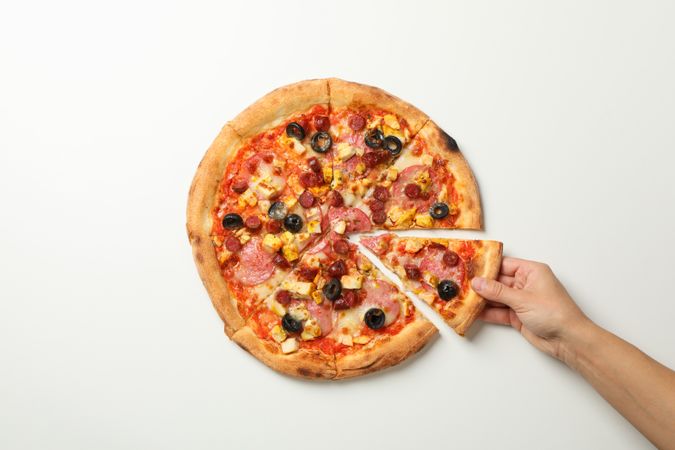 Female hand holds tasty pizza on plain background