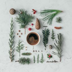 Creative layout made of winter branches, on marble background with coffee