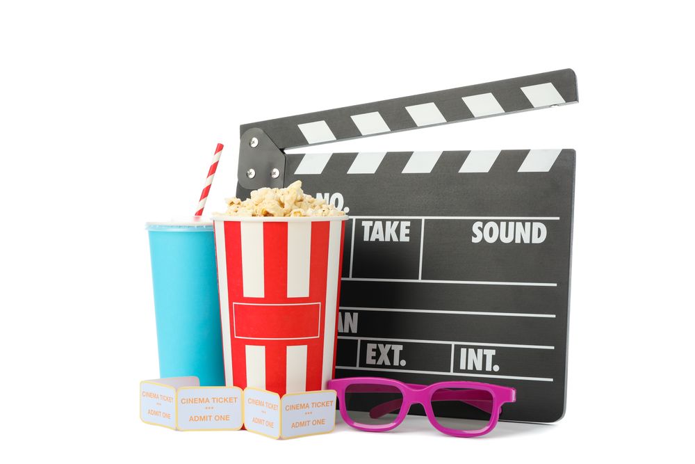 Clapperboard, paper cup, bucket with popcorn, tickets and 3d glasses isolated on studio background