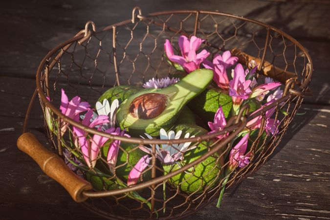 Colorful flowers with avocado in basket
