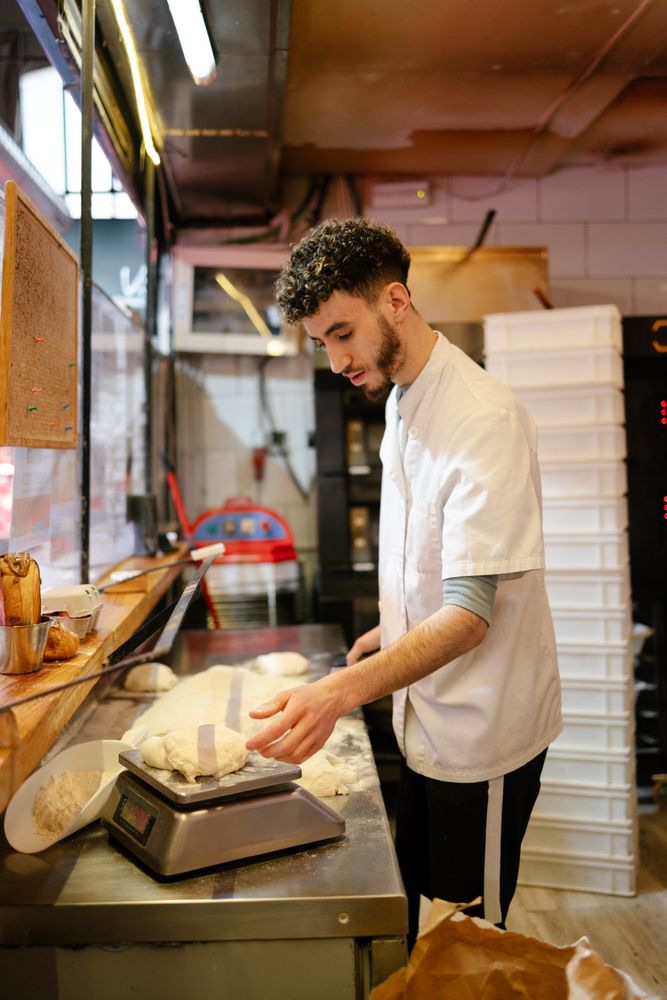 Pizza man weighing the dough on a scale