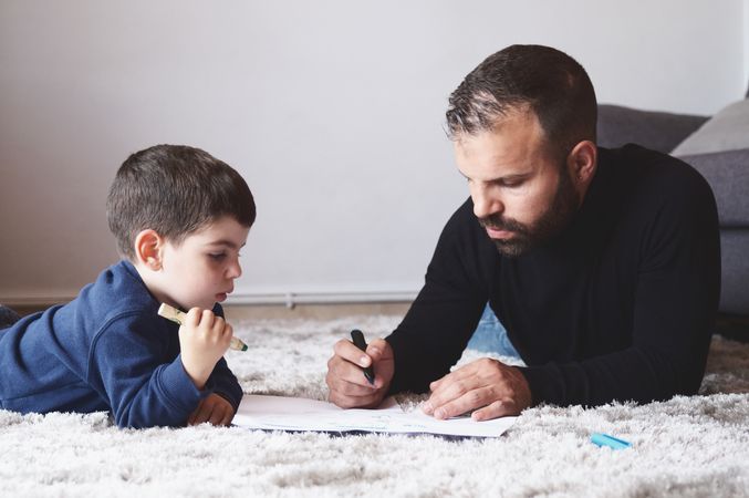 Father and son drawing on floor