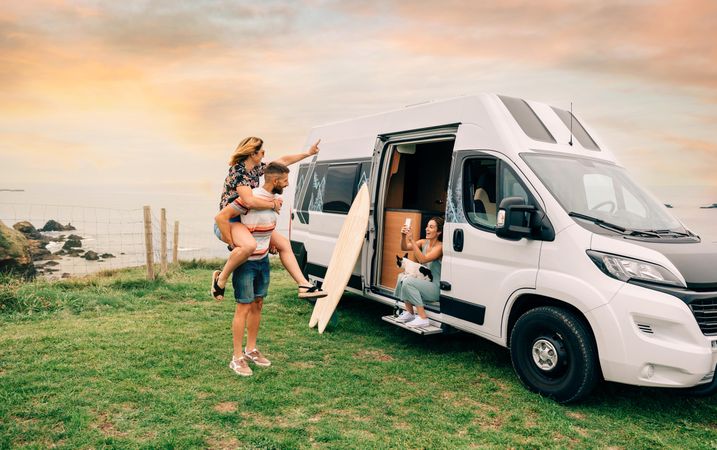 Friend sitting in motorhome taking picture of playful couple