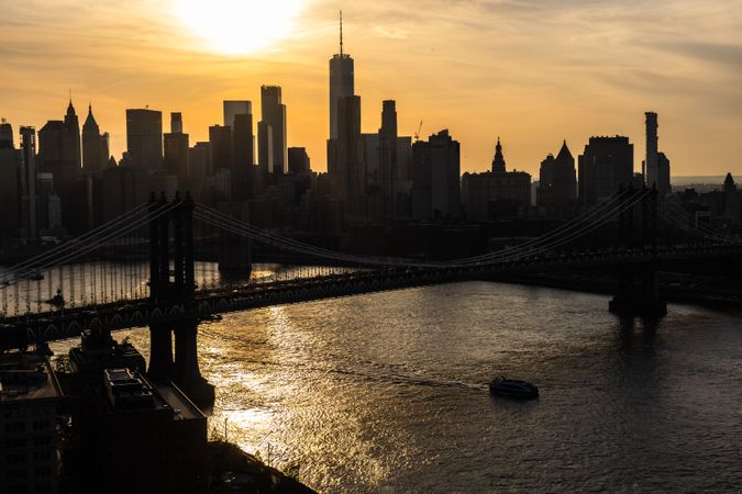 New York City Skyline Aerial Photo from a Helicopter at Sunset. Famous Skyscraper Buildings with Manhattan Bridge. Busy Diverse Megapolis with Cars, Boats and People Moving Around