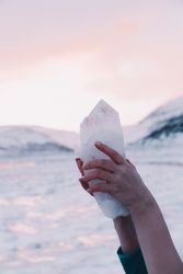 Woman holding amazing stone near hills