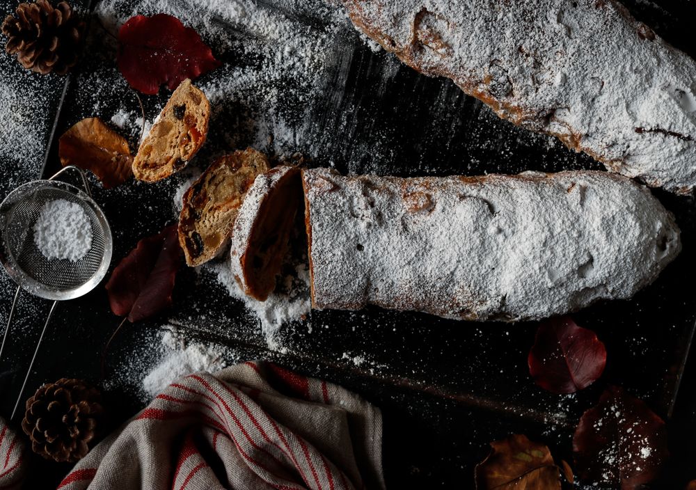 Pieces of Stollen near sieve and autumn leaves