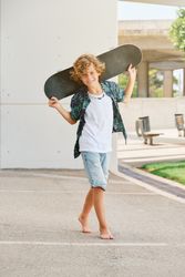Barefoot boy with skateboard on street