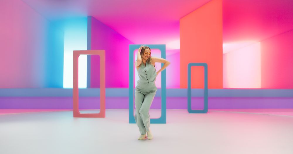 Portrait of a Talented Young Female Artist Showcasing Graceful Movements and Expressive Joyful Emotions with Her Innovative Modern Dance Routine in a Colorful Neon Lit Spacious Studio