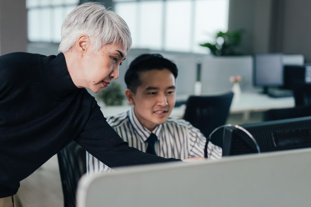 Older woman and man working together in an office