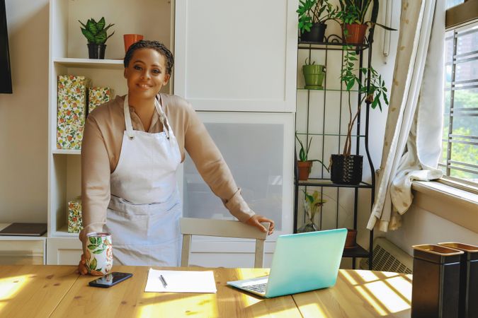 Portrait of female entrepreneur in work apron in bright office
