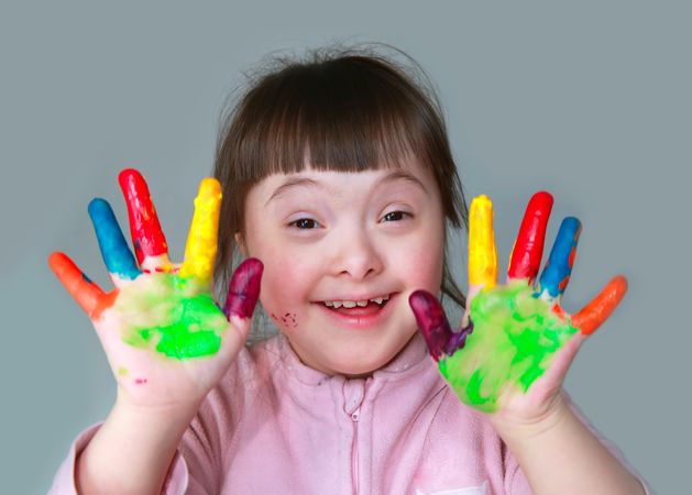 Adorable little girl holding painted hands up