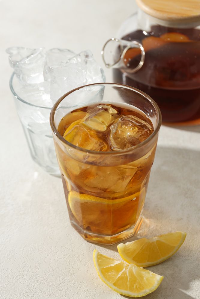 A glass of delicious cold tea on a plain background