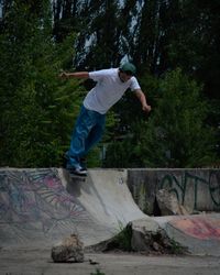 Man in light shirt skating on a mini ramp