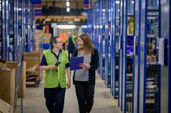Two women walking through warehouse