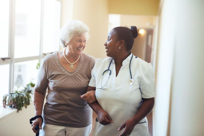 Nurse assisting older woman
