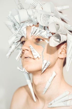 Portrait of topless young man with paper cones on his head