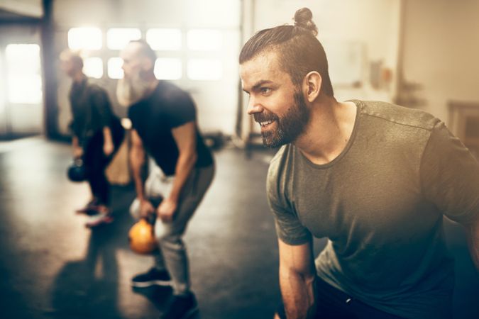 Man working out with group of people in class with kettlebells