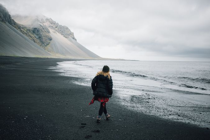 Woman walking on rocky coast on a winter’s day