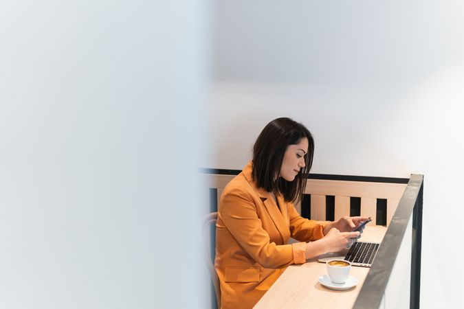 Woman using smartphone and working in cafe