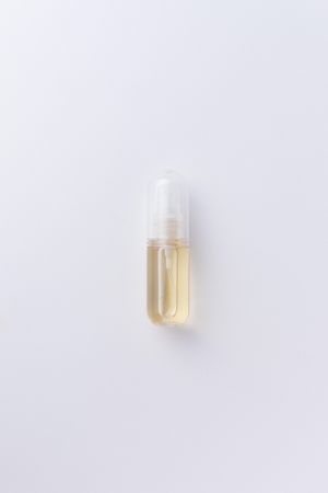 Small perfume bottle over pale background