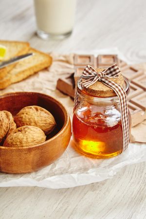 Pot of honey with whole walnuts and chocolate