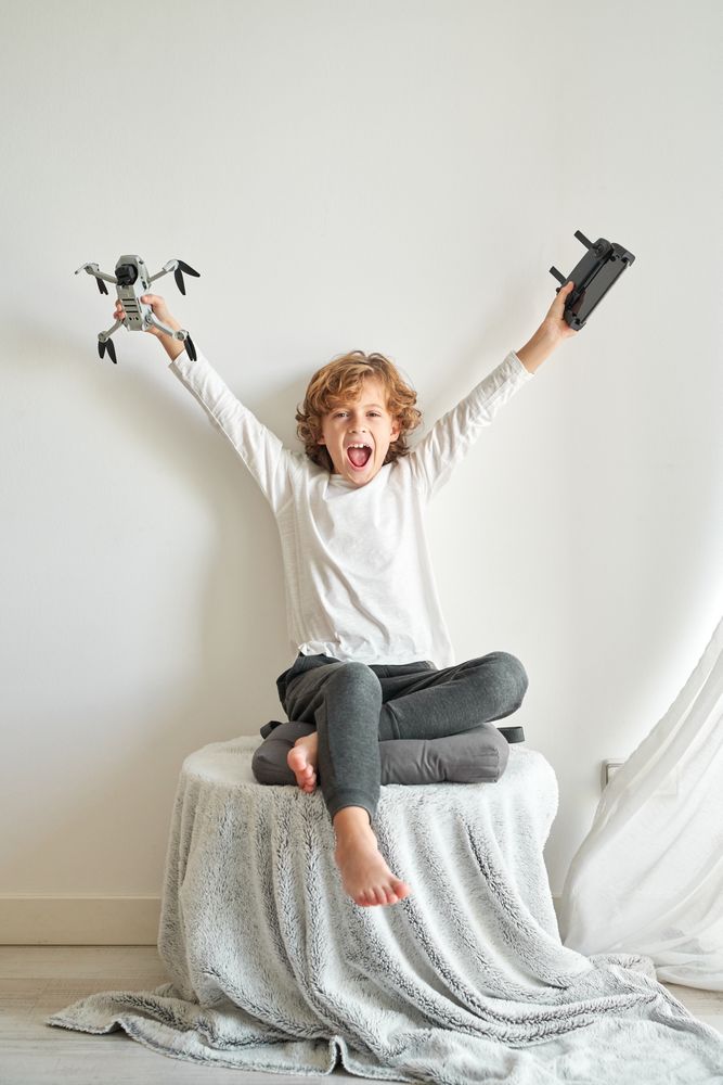 Excited preteen boy rejoicing gifted drone with remote control
