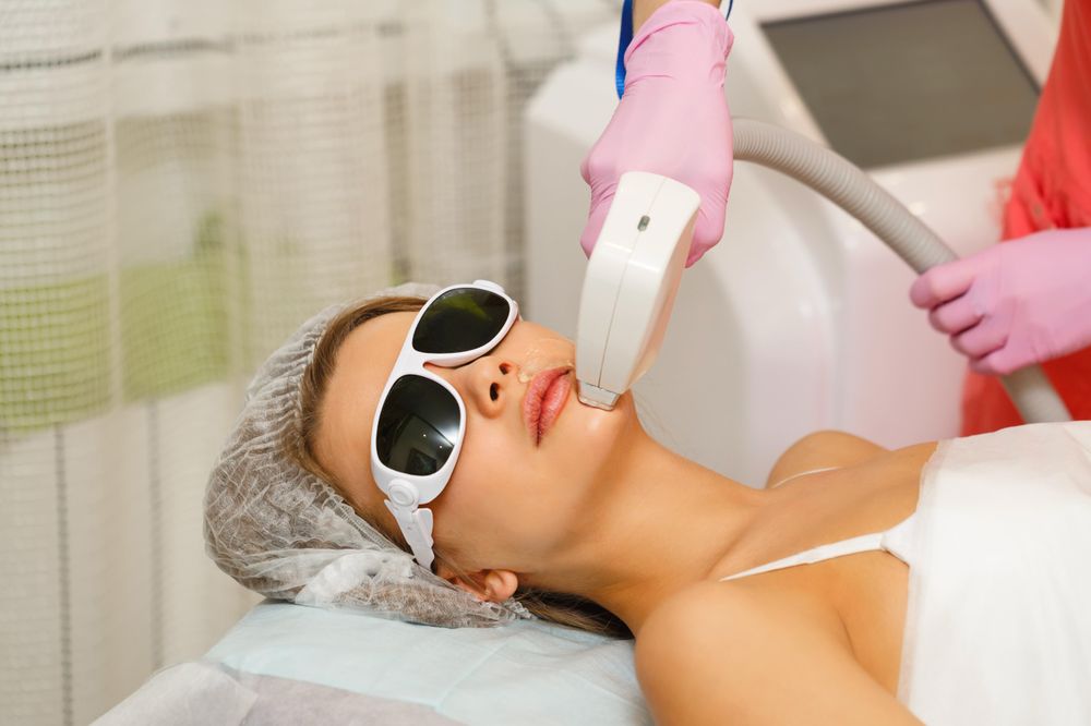 Female with laser hair machine working on chin