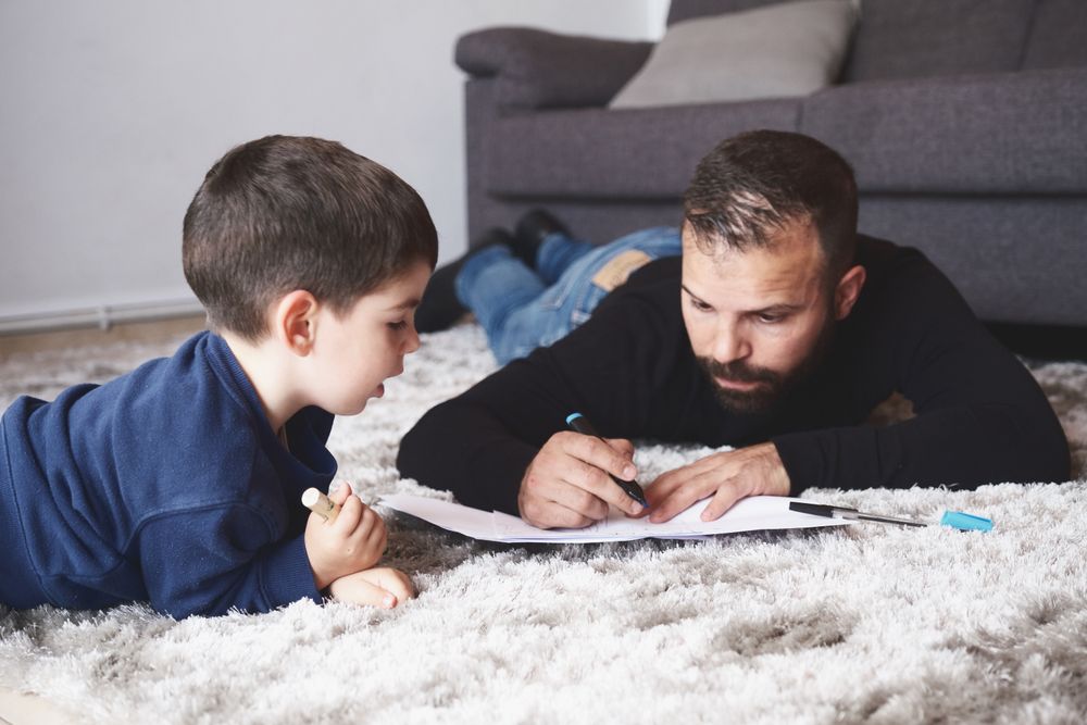 Father and son drawing on floor