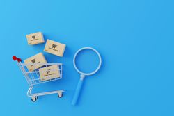 Shopping Cart with Parcel Boxes and Magnifying Glass on Blue Background