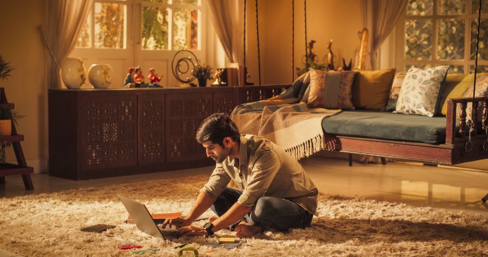 Focused Indian Man Studying at Home: Engaged in Learning, Researching, and Project Management.