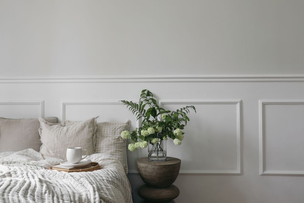 Bed with tray of coffee and vase with flowers