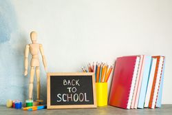 Composition with school supplies on grey table against light background