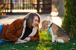 Woman sitting with beagle puppy in backyard